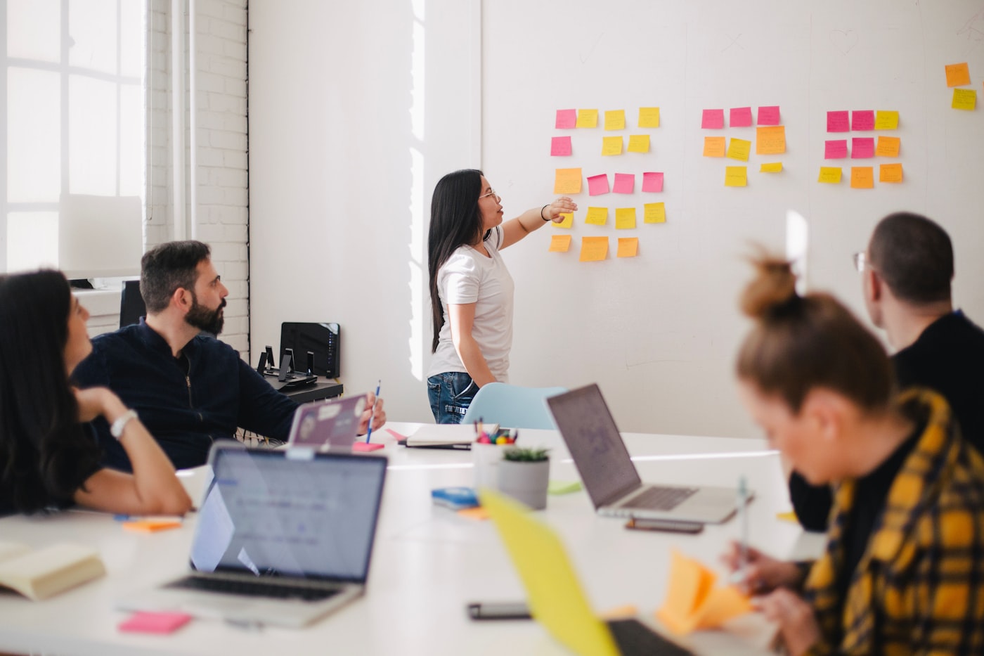 Consultants working through a process diagram together at a conference table