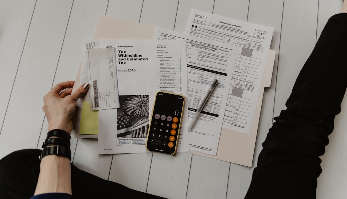Financial analyst reviewing reports and a calculator at a desk